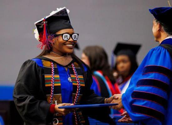 A 澳门新普京注册 graduate with 2024 glasses accepts her degree